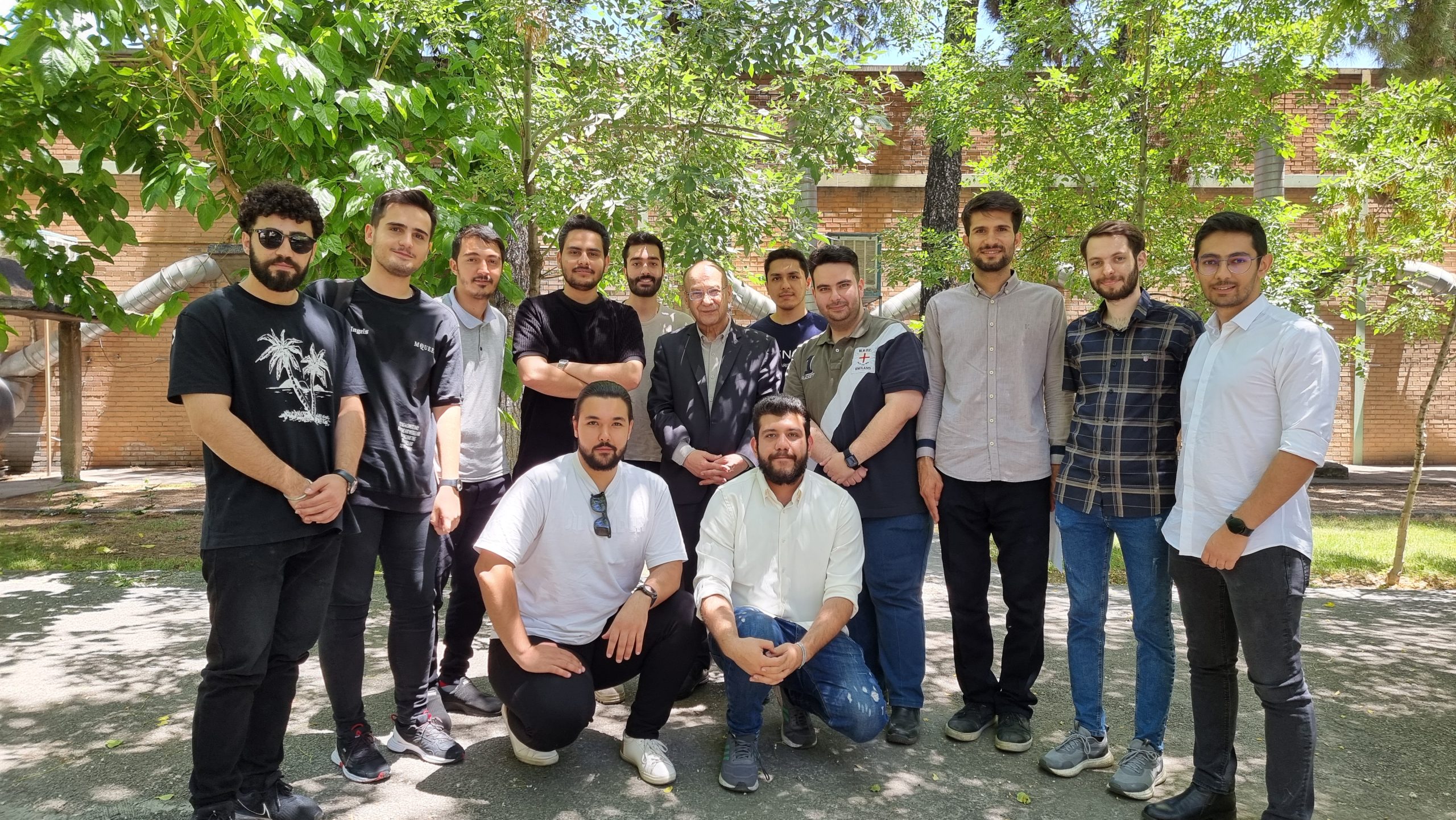 Group photo featuring Dr. Parviz Ghodusi alongside students from the Master's program, capturing a memorable moment of academic achievement.